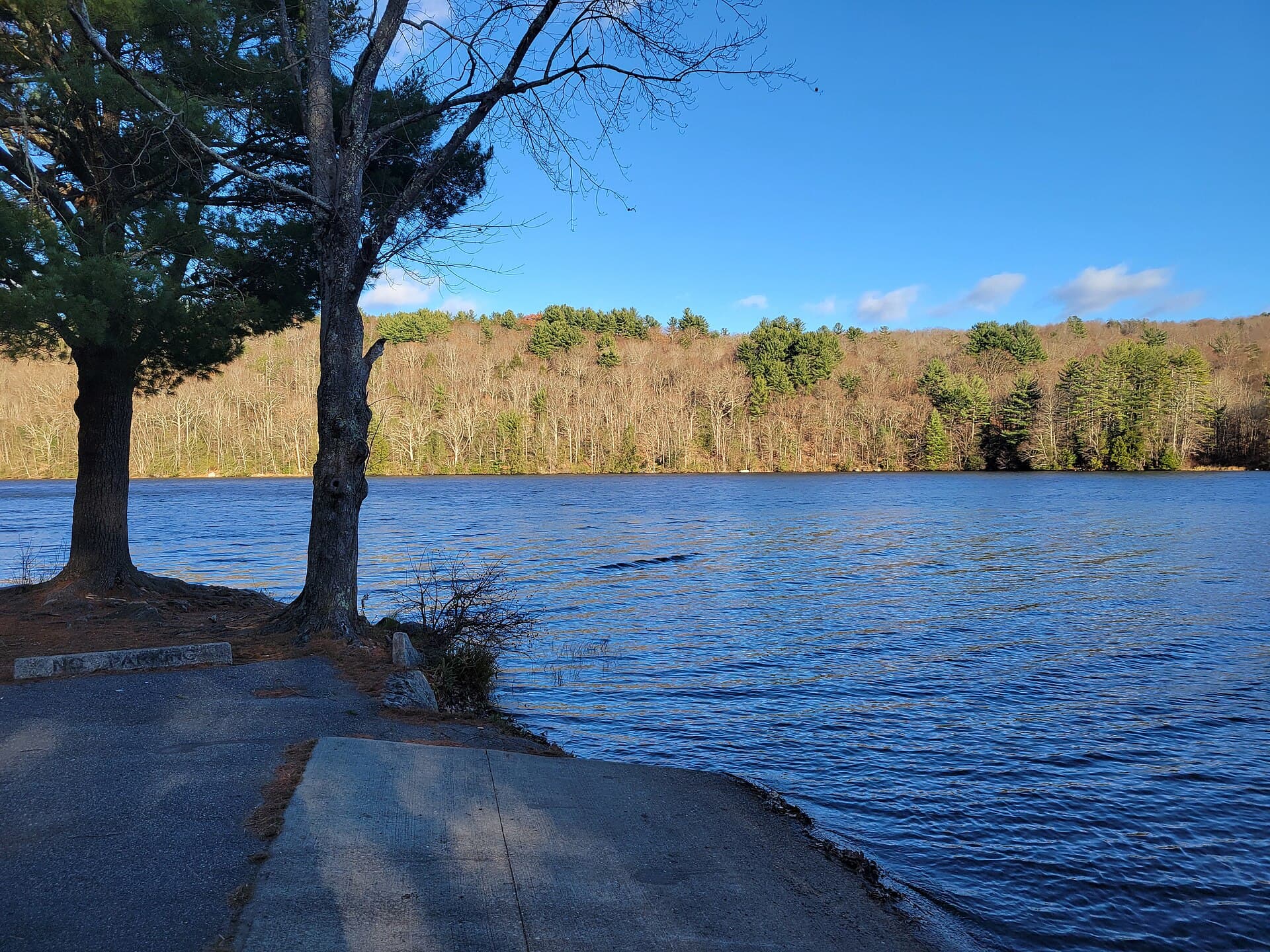Stillwater Pond in Torrington under a clear blue sky, trees along the far shore