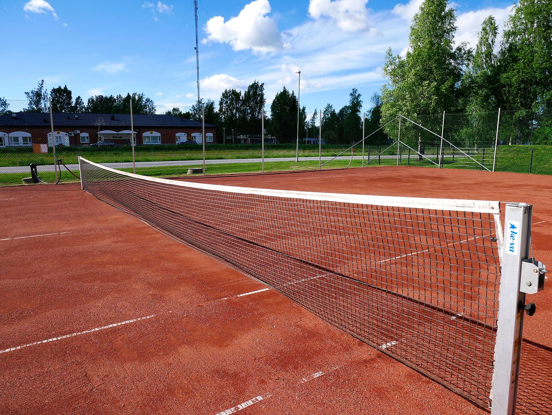 A tennis net stretched across a clay court